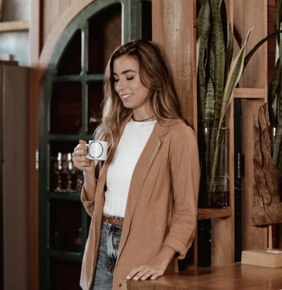 Laís tomando café, pensativa