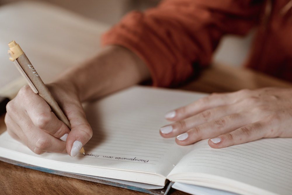 Mãos escrevendo um planejamento no caderno